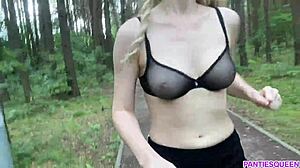 Blondi nainen harjoittelee ulkona puistossa, paljastaen alaston vartalonsa ja pomppivat rinnat